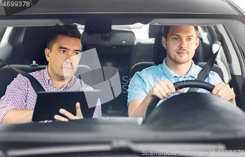 Image of car driving school instructor and young driver