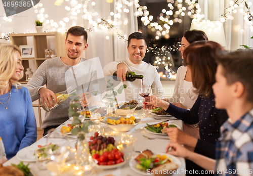 Image of happy family having dinner party at home