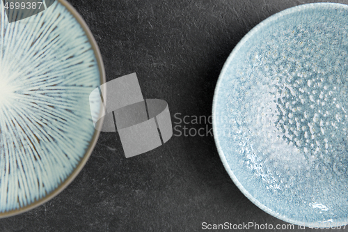 Image of close up of blue ceramic plate on slate background