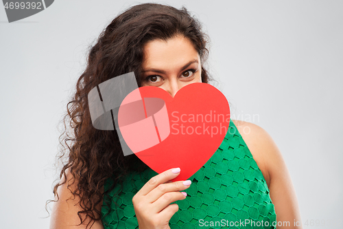 Image of happy woman in green dress holding red heart