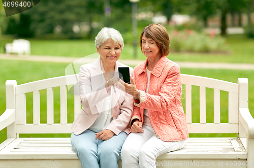 Image of happy senior women with smartphone at summer park