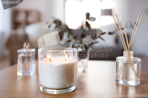 Image of aroma reed diffuser, burning candle and perfume