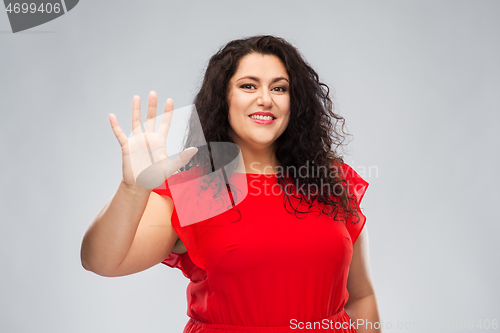 Image of happy woman in red dress showing five fingers