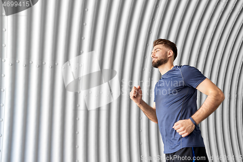 Image of sporty young man running in tunnel