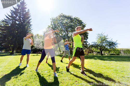 Image of group of friends or sportsmen exercising at park