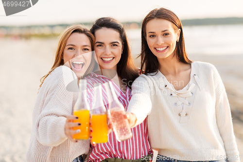 Image of young women toasting non alcoholic drinks on beach