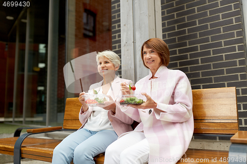 Image of senior women eating takeaway food on city street