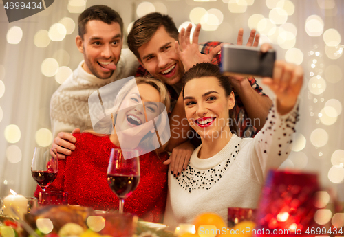 Image of friends taking selfie at christmas dinner