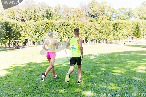 Image of happy couple of sportsmen racing wit badge numbers