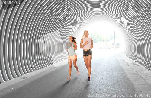 Image of young women or female friends running outdoors