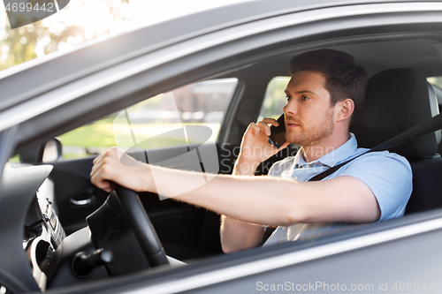 Image of man driving car and calling on smartphone