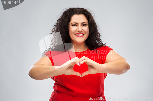 Image of happy woman in red dress showing hand heart