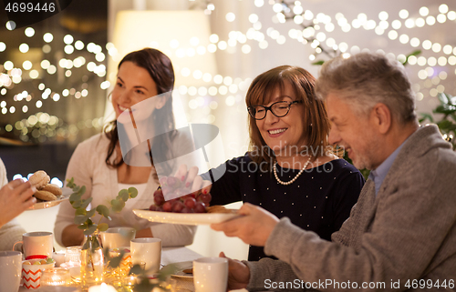 Image of happy family having tea party at home