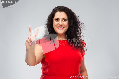 Image of happy woman in red dress showing peace hand sign