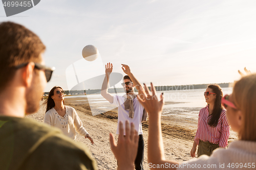 Image of friends playing volleyball on beach in summer