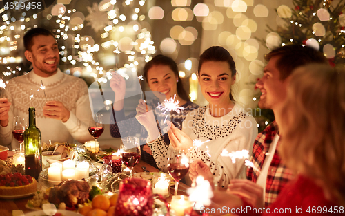 Image of happy friends celebrating christmas at home feast