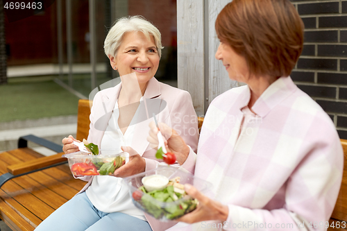 Image of senior women eating takeaway food on city street