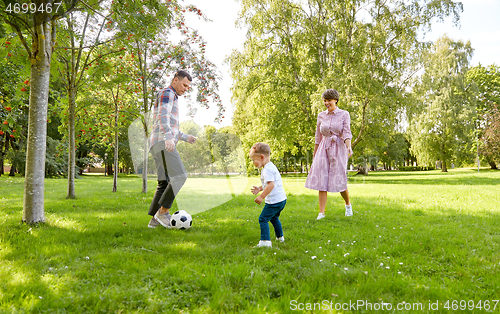 Image of happy family playing soccer at summer park