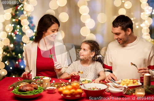 Image of happy family having christmas dinner at home