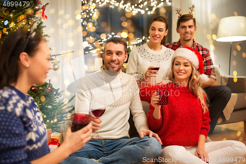 Image of friends celebrating christmas and drinking wine