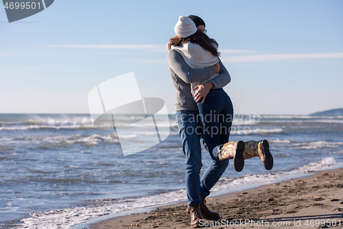 Image of Loving young couple on a beach at autumn sunny day