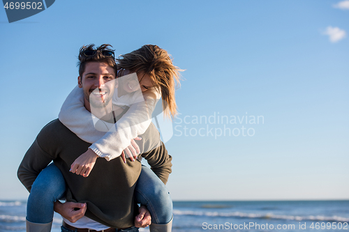 Image of couple having fun at beach during autumn