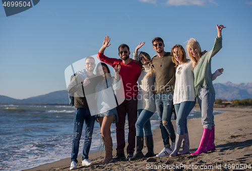 Image of portrait of friends having fun on beach during autumn day