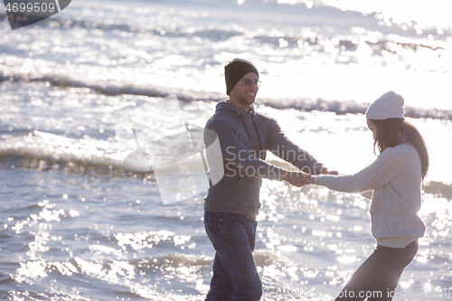 Image of Loving young couple on a beach at autumn sunny day