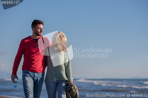 Image of Loving young couple on a beach at autumn sunny day