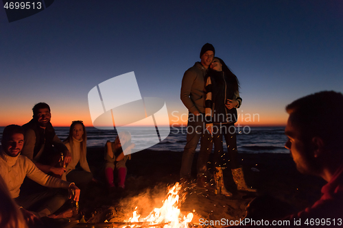 Image of Friends having fun at beach on autumn day