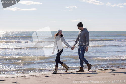 Image of Loving young couple on a beach at autumn sunny day