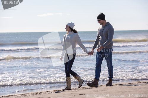 Image of Loving young couple on a beach at autumn sunny day