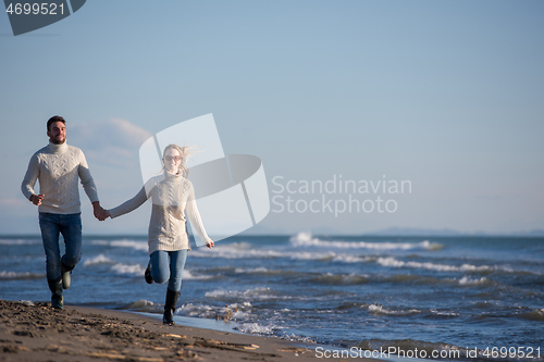 Image of Loving young couple on a beach at autumn sunny day