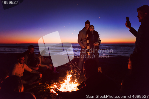 Image of Friends having fun at beach on autumn day