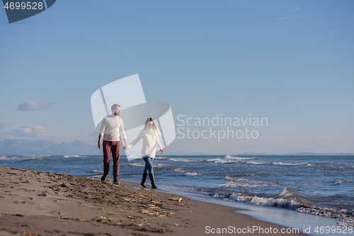 Image of Loving young couple on a beach at autumn sunny day