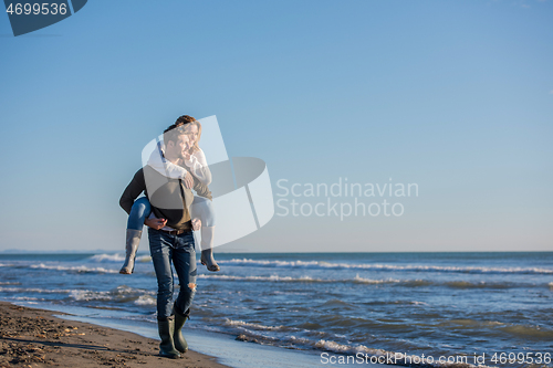 Image of couple having fun at beach during autumn