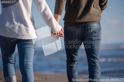 Image of Loving young couple on a beach at autumn sunny day