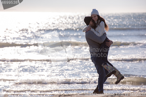 Image of Loving young couple on a beach at autumn sunny day