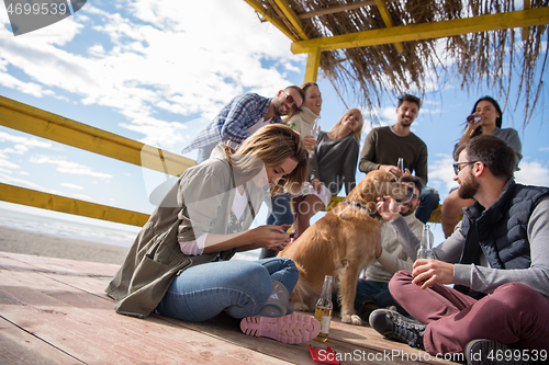 Image of Group of friends having fun on autumn day at beach