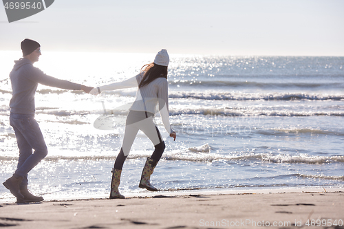 Image of Loving young couple on a beach at autumn sunny day