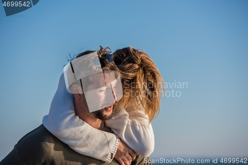 Image of couple having fun at beach during autumn