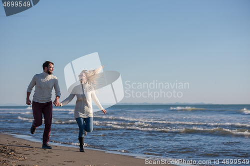 Image of Loving young couple on a beach at autumn sunny day