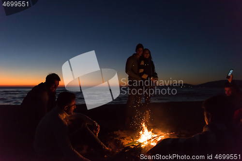 Image of Friends having fun at beach on autumn day