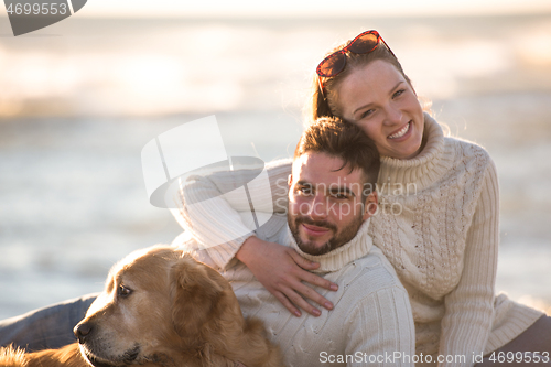 Image of Couple with dog enjoying time on beach