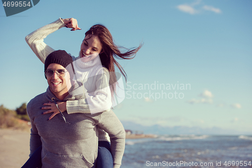 Image of couple having fun at beach during autumn