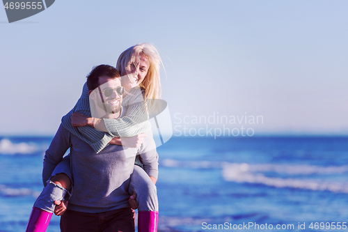 Image of couple having fun at beach during autumn