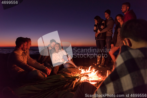 Image of Friends having fun at beach on autumn day