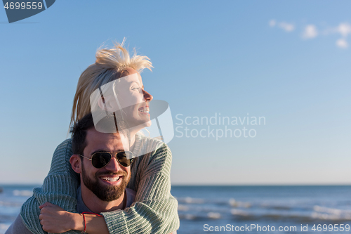 Image of couple having fun at beach during autumn