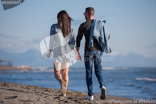 Image of Loving young couple on a beach at autumn sunny day