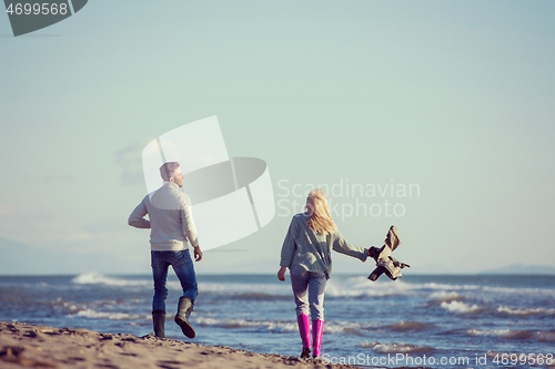 Image of Loving young couple on a beach at autumn sunny day